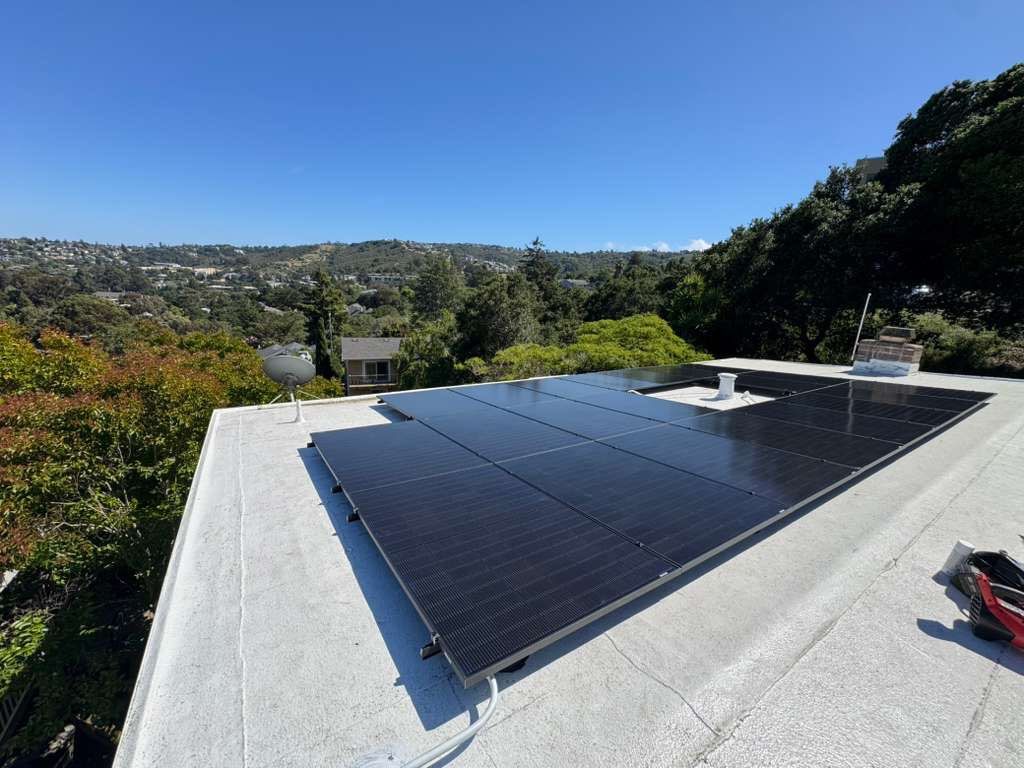 Completed all-black rooftop solar array on a Belmont home with panoramic view of surrounding hills and neighboring rooftops.