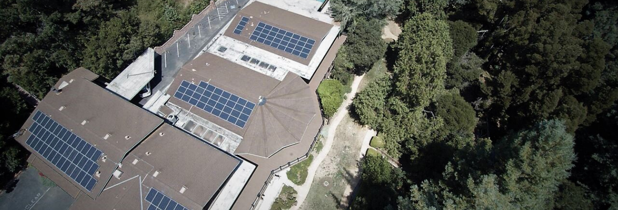 Aerial view of Saint Clare's Retreat with rooftop solar arrays in Soquel, California