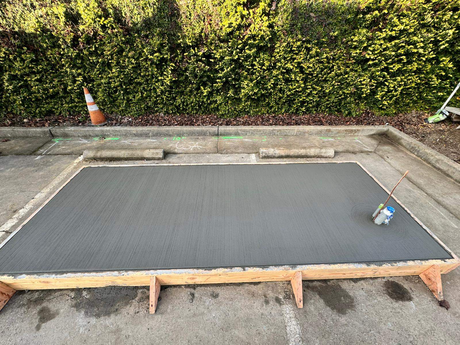 Freshly finished concrete equipment pad with conduit stub-ups, formed and ready for the Healdsburg commercial battery storage cabinets.