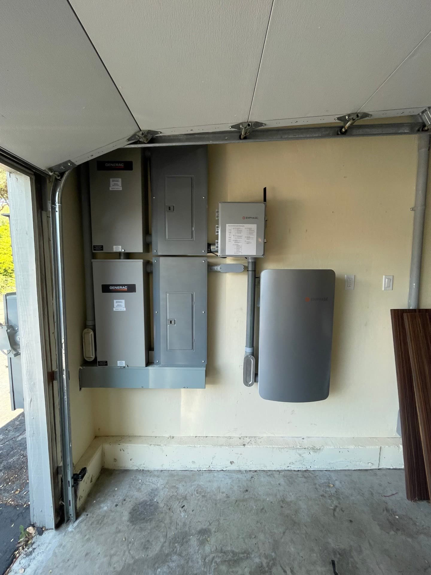 Garage installation of a Generac automatic transfer switch, main load center, and Enphase IQ Battery for a Morgan Hill home.