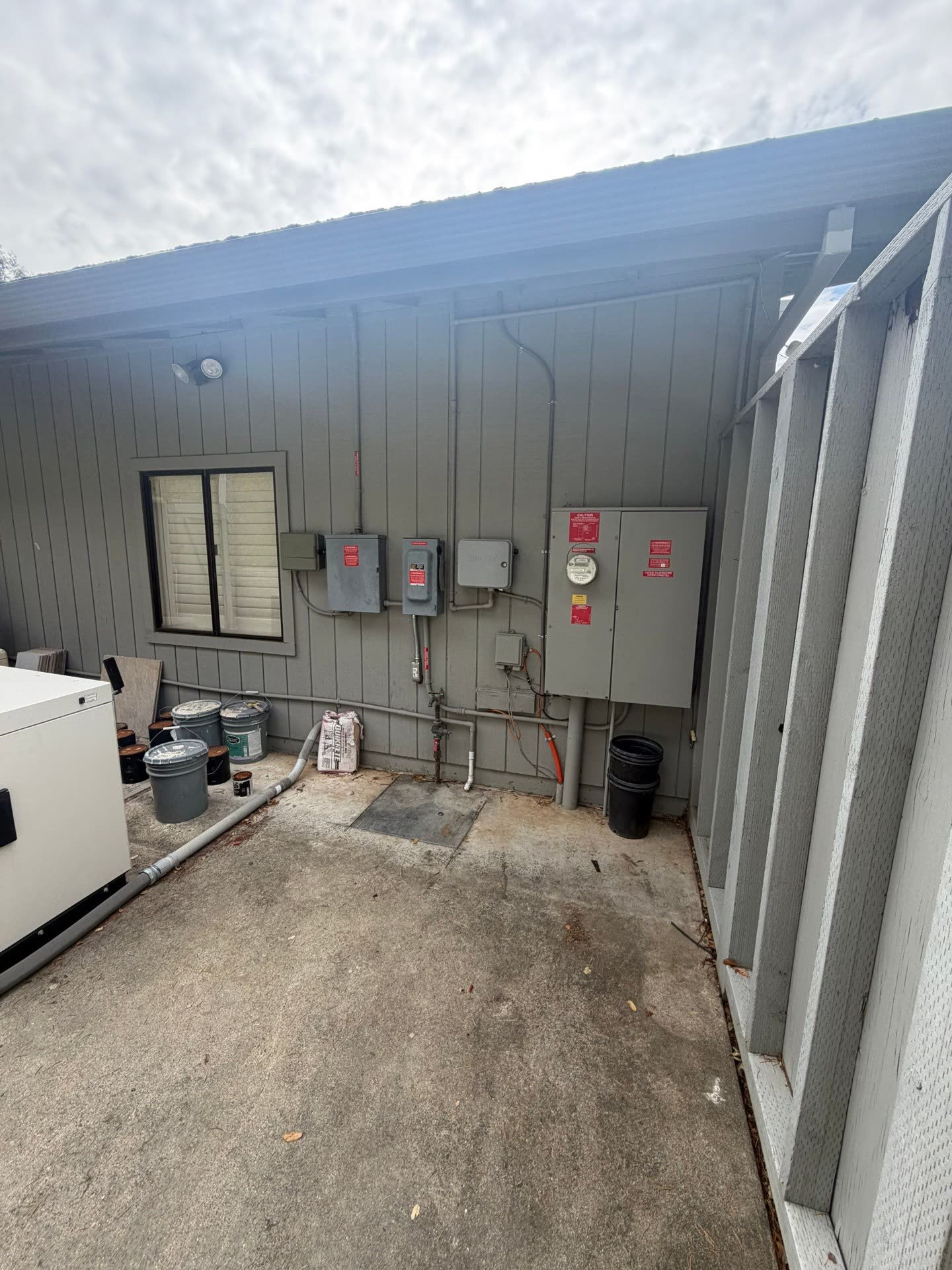 Exterior electrical service equipment for a Morgan Hill solar-plus-storage project, including main disconnect, meter, and PV subpanels.