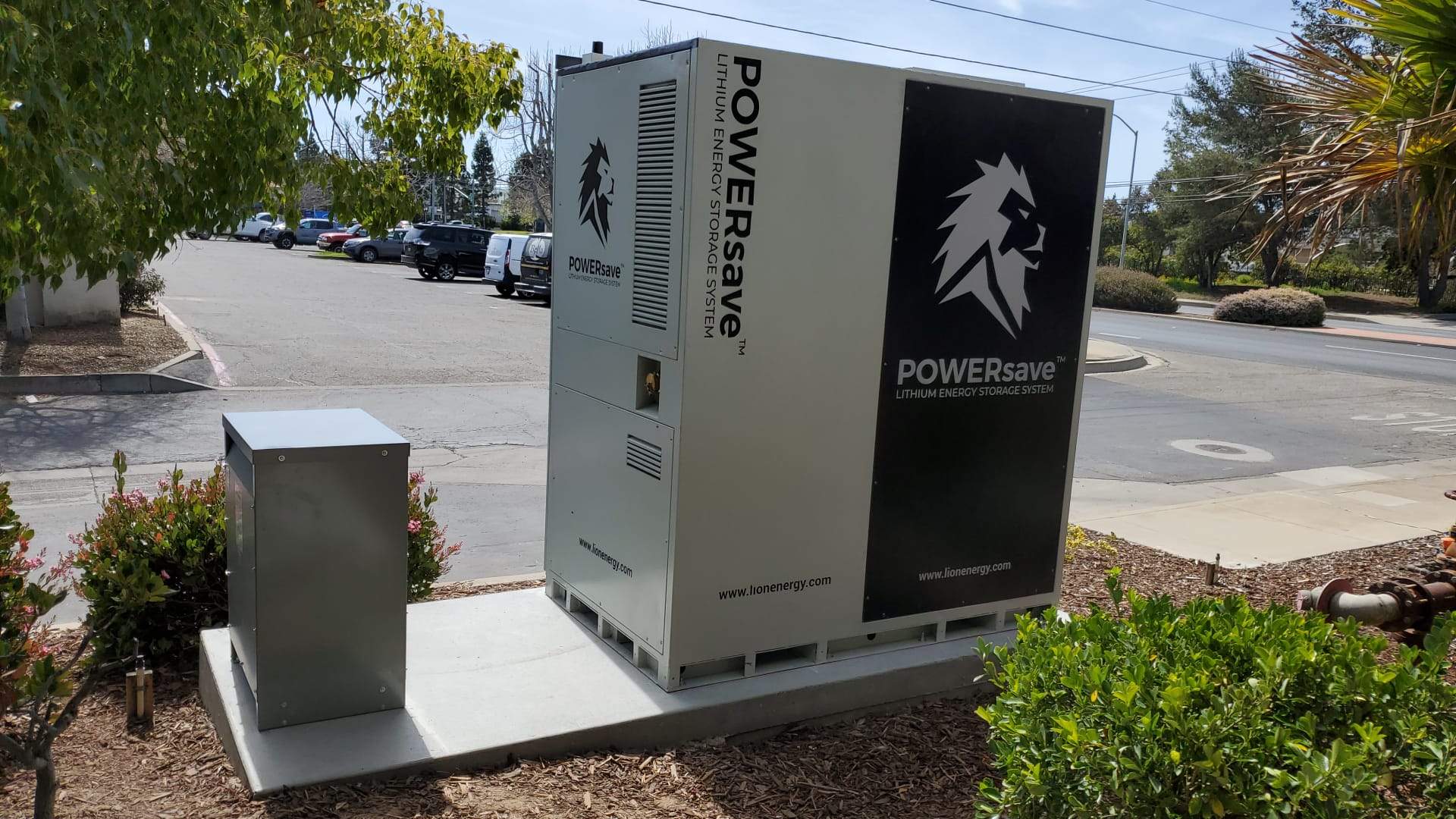 Lion Energy POWERsave commercial lithium energy storage system with adjacent disconnect enclosure, installed on a concrete pad at a Santa Maria commercial property.