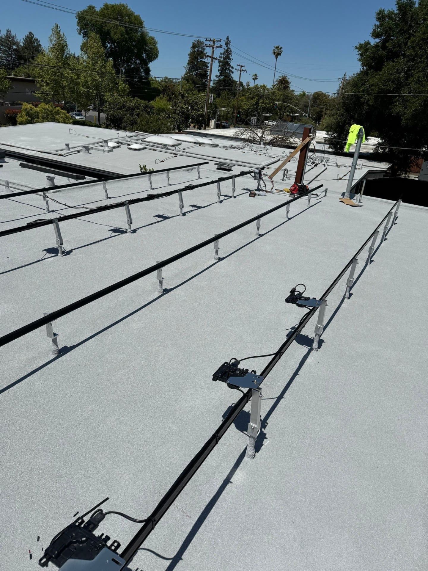 In-progress rail and microinverter layout on a low-slope Sunnyvale roof before modules are set.