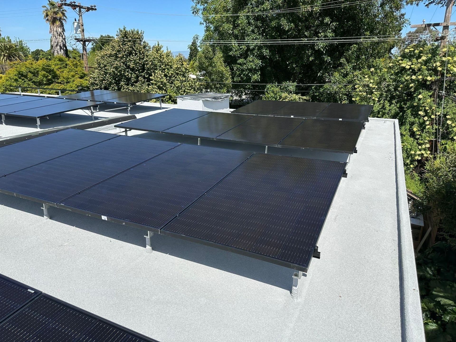 Close-up of a completed low-slope roof solar array on a Sunnyvale home, showing crisp module alignment and rail spacing.